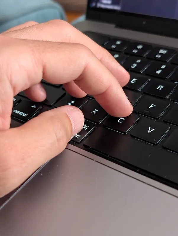 My hand, ready to copy text on my Macbook keyboard